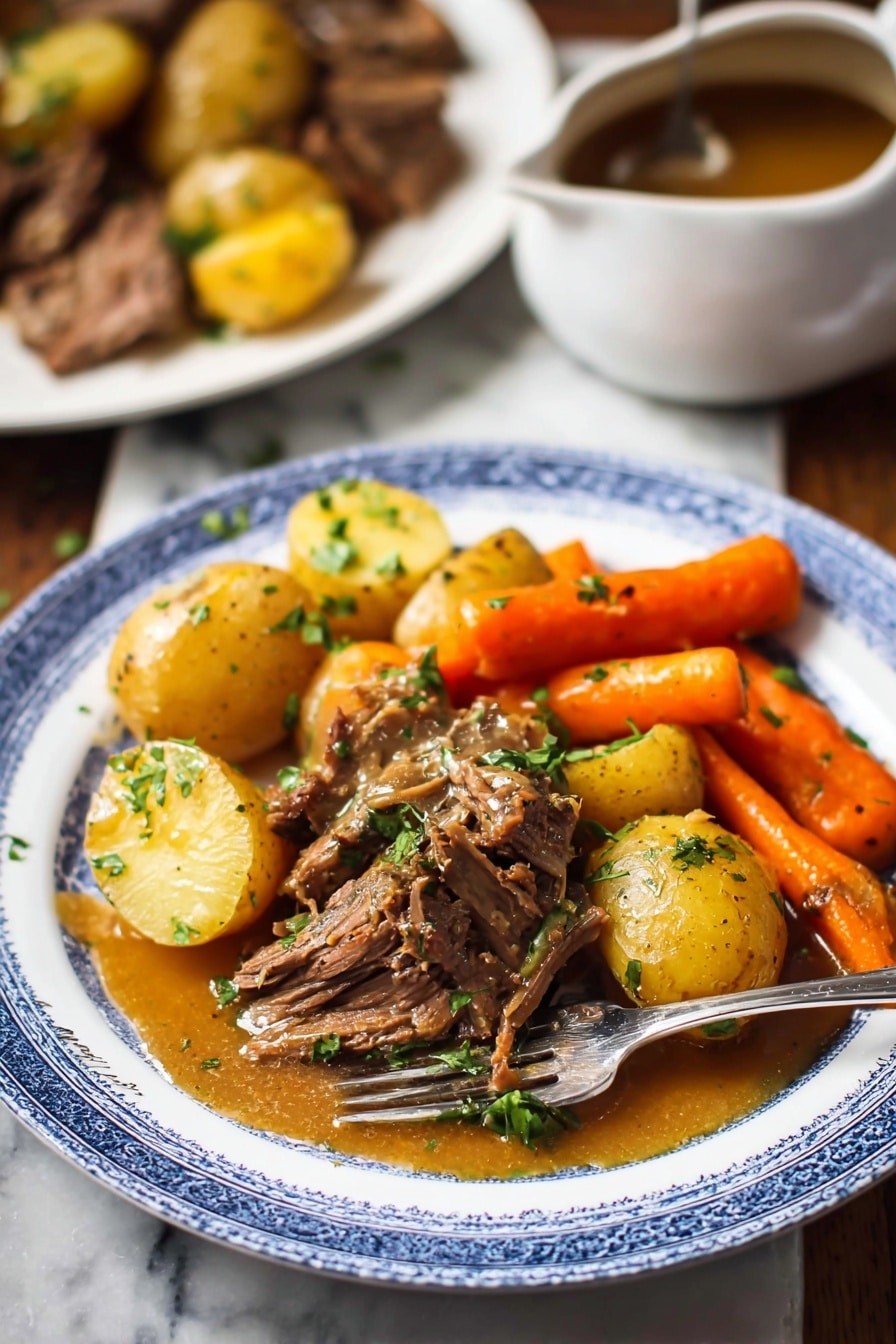 Slow Cooker Pot Roast with Root Vegetables and Herb-Infused Gravy, tender beef roast, hearty slow cooker dinner, comfort food recipes, easy holiday pot roast - A white plate with a blue rim holds a hearty meal featuring three main layers: golden brown pieces of cooked beef in the center topped with chopped green herbs, tender yellow baby potatoes scattered around the beef, and bright orange carrot sticks positioned near the back. A golden brown sauce with a smooth texture lightly covers parts of the beef and potatoes. A silver fork rests on the plate's edge. In the background, there is a white marbled surface with a blurred white plate containing more beef and potatoes, and a white saucepan with brown sauce on the left side. The overall scene has warm, natural lighting. photo taken with an iphone --ar 2:3 --v 7