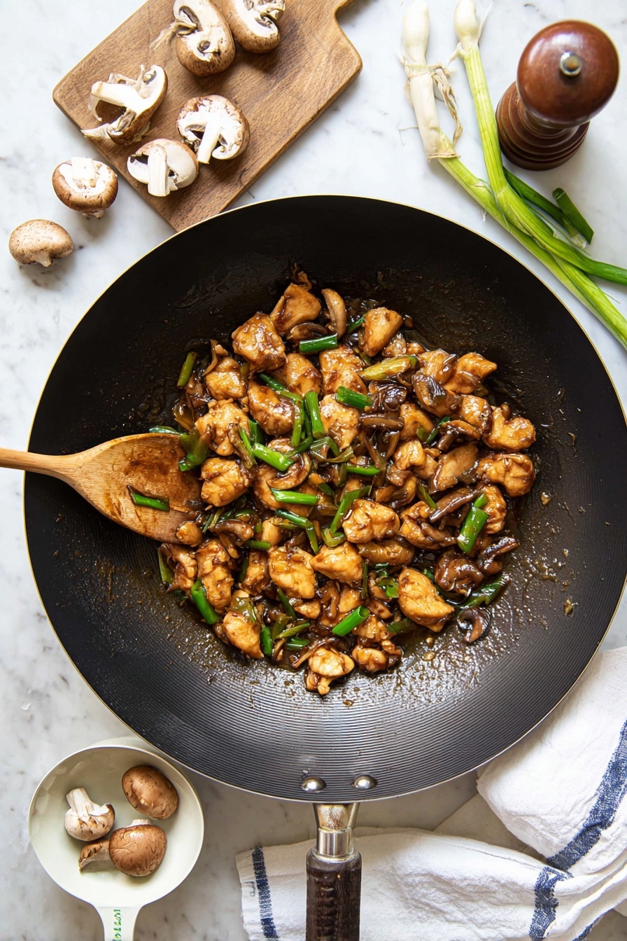 Black Pepper Mushroom Chicken Stir Fry, mushroom chicken stir fry, black pepper chicken, easy Asian stir fry, quick weeknight dinner - A large black wok filled with several small pieces of golden-brown cooked chicken mixed with sliced brown mushrooms and bright green chopped spring onions, all coated in a glossy brown sauce. A wooden spoon stirs the mixture from the left side of the wok. Around the wok, there are whole and sliced mushrooms, a wooden pepper grinder, fresh green spring onions on a small wooden board, and a white measuring cup holding two mushrooms. The entire scene is set on a white marbled surface with a white cloth towel showing blue stripes placed under the wok’s handle. photo taken with an iphone --ar 2:3 --v 7