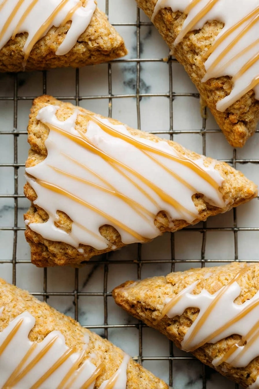 Starbucks Copycat Vegan Pumpkin Scones, vegan pumpkin scones, plant-based pumpkin scones, gluten-free pumpkin scones, fall vegan baking ideas - A close-up of a single orange-brown bar with a soft, crumbly texture showing a bite taken on one side, topped with a thick layer of smooth, creamy white icing drizzled in parallel lines across the top. The bar is held delicately by a woman's hand with a blurred white marbled background. The focus is on the detailed texture of the bar and the glossy icing with a warm, soft lighting. Photo taken with an iphone --ar 2:3 --v 7