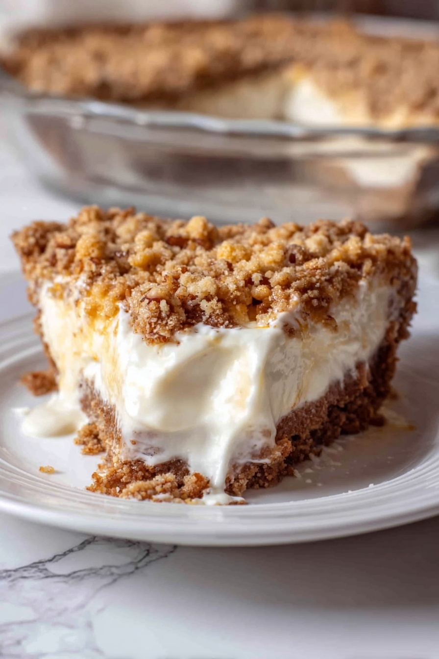 Angel Pecan Pie HoneySweet Pecan Pie Fluffy Pecan Pie Buttery Crust Pecan Pie - A close-up of a slice of pie on a white plate with a white marbled surface underneath. The pie has three visible layers: a crumbly brown crust at the bottom, a thick creamy white filling in the middle that is slightly melting and spreading on the plate, and a chunky golden brown crumb topping with some small nut bits on top. In the background, part of a clear glass dish shows the rest of the pie with the same three layers. The photo taken with an iphone --ar 2:3 --v 7