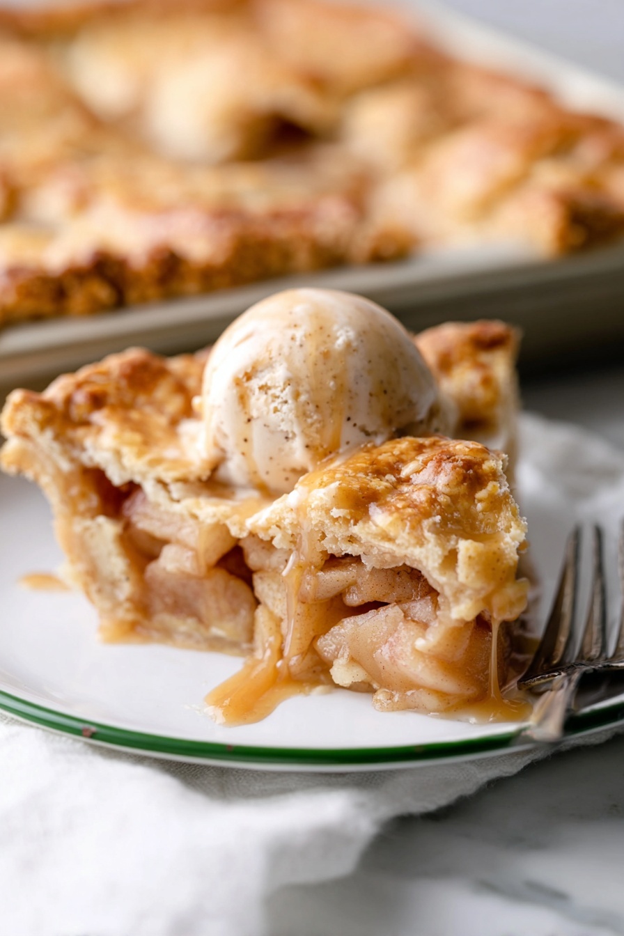 Best Apple Slab Pie, easy apple slab pie recipe, homemade apple slab pie, flaky apple pie bake, orchard-style apple slab dessert - A white plate with a green rim holds a slice of apple pie topped with a scoop of cinnamon ice cream. The pie slice has several golden, flaky layers of crust on top and bottom, filled with soft, light brown cooked apple pieces surrounded by a glossy syrup. On the ice cream, dark brown caramel sauce slowly drips down the sides. In the background, part of the remaining pie sits on a baking tray on a white marbled surface, with a silver fork nearby. photo taken with an iphone --ar 2:3 --v 7