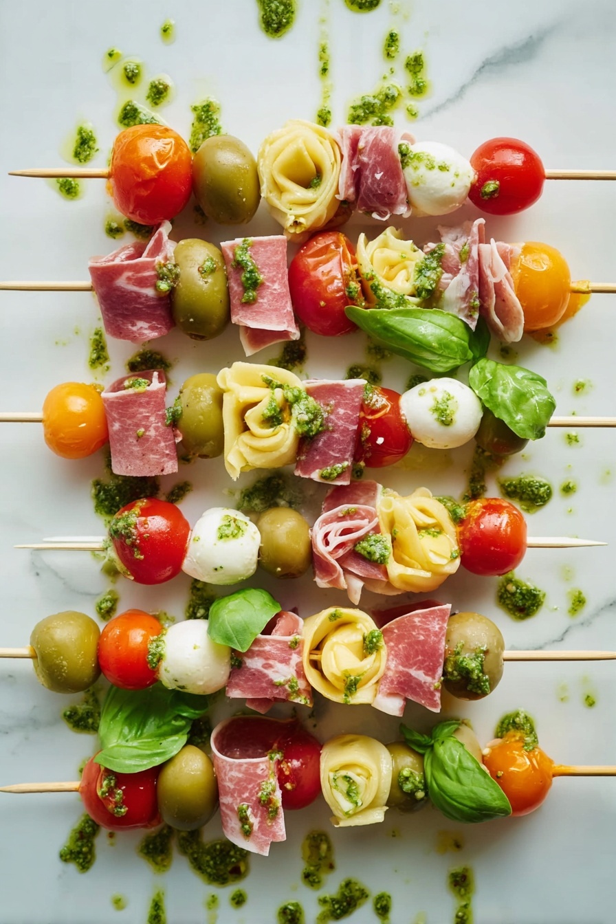 Antipasto Skewers with Tortellini and Cheese, appetizer ideas, party snack recipes, easy antipasto skewers, colorful finger foods - The image shows several skewers with five to seven layers each, arranged side by side on a white marbled surface. Each skewer has colorful ingredients stacked in this order from top to bottom: red cherry tomatoes or orange cherry tomatoes, green basil leaves or whole green olives, light yellow tortellini pasta, thin swirled slices of pink cured meat, and white cheese cubes or white mozzarella balls. Some layers also have small pieces of bright red roasted pepper. Green pesto sauce is drizzled over the skewers and on the surface around them, adding an extra texture and shine to the image. The overall look is fresh, vibrant, and neatly arranged. photo taken with an iphone --ar 2:3 --v 7