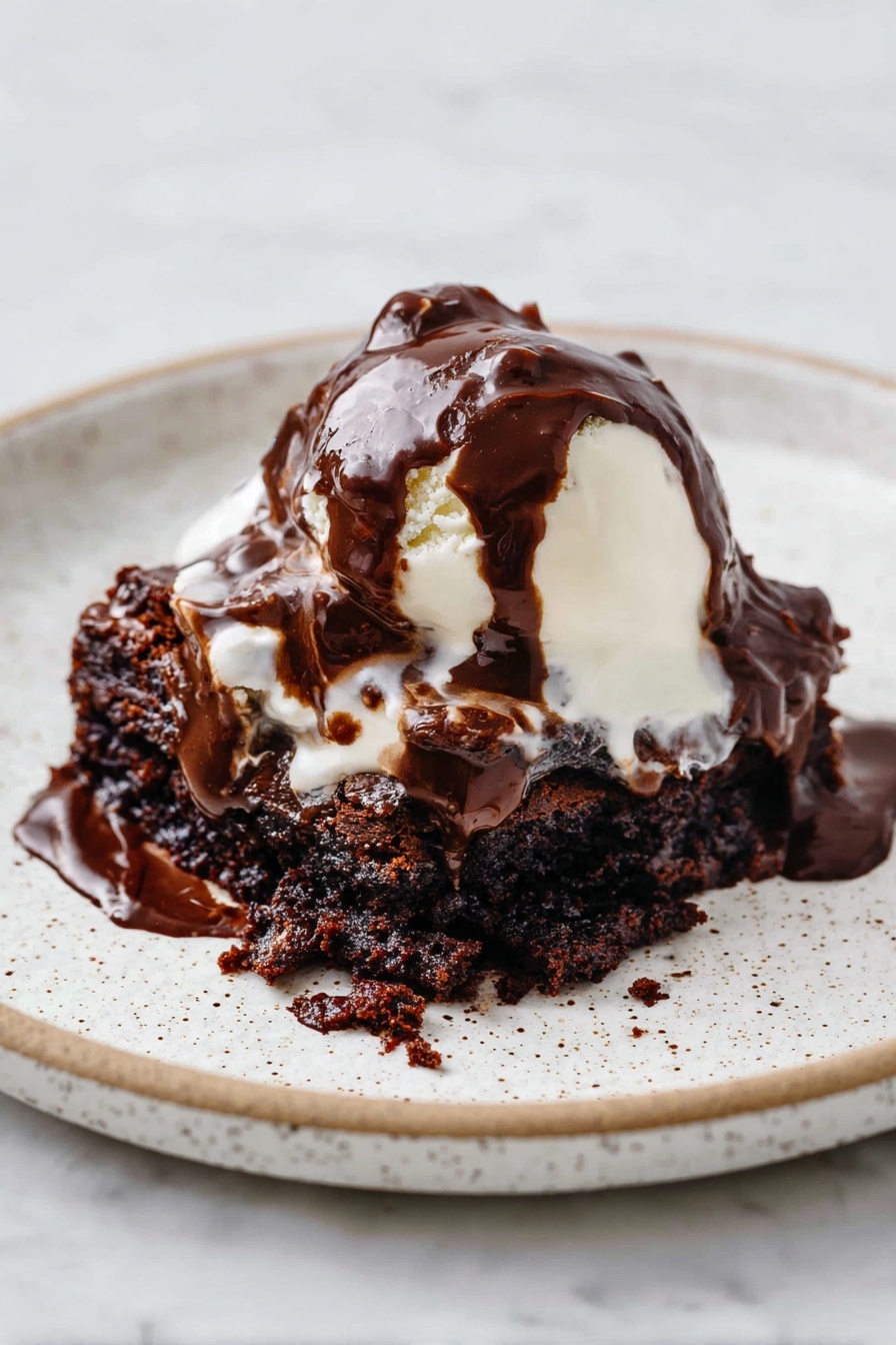 Hot Fudge Cake with Self-Saucing Chocolate, Chocolate Self-Saucing Cake, Gooey Chocolate Dessert, Easy Chocolate Cake, Warm Fudge Cake - A white speckled plate holds a dessert with three main layers. The bottom layer is a dark brown, moist chocolate cake with a rough, crumbly texture. On top of this is a soft, white scoop of melting ice cream that is smooth and creamy. The top layer is thick, glossy dark chocolate sauce, generously poured over the ice cream and cake, flowing and blending into the layers below. The plate sits on a white marbled surface. photo taken with an iphone --ar 2:3 --v 7