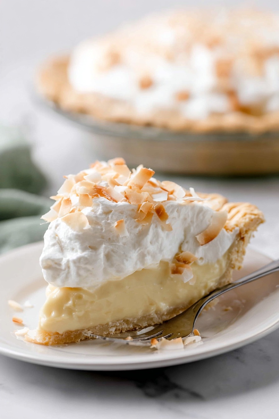 Homemade Coconut Cream Pie, coconut cream pie recipe, tropical dessert, easy coconut pie, homemade pie with coconut - A slice of pie is shown on a white plate, with three clear layers. The bottom layer is a light golden crust with a slightly crumbly texture. The middle layer is thick and creamy, pale yellow in color, smooth and soft looking. The top layer is white whipped cream, fluffy, covered with toasted coconut flakes that are light brown and white, scattered unevenly. The pie is on a white marbled surface, and in the background, the rest of the pie is visible in a clear pie dish. A silver fork with text is placed beside the slice on the plate. photo taken with an iphone --ar 2:3 --v 7